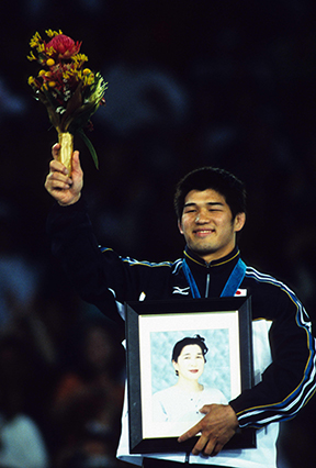 シドニー・オリンピック100kg級で金メダルを獲得し、母の遺影を掲げて表彰式に臨む。（2000年）