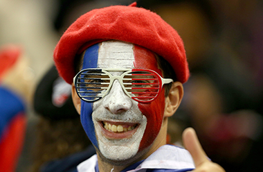 国旗の三色でフェイスペインティングをするフランスサポーター