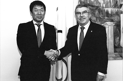 IOCのトマス・バッハ会長（右）と  堅い握手を交わす（2016年）