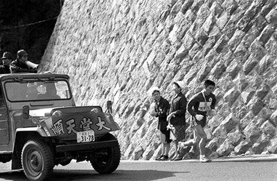 往路5区で伴走車からの監督の激励を受け山登りに挑む選手（1968年1月）
