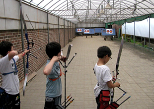 小学校の学校運動部（アーチェリー）で練習に励む子どもたち