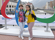 パラリンピック・シンボルの前で<br>ポーズをとるボランティア
