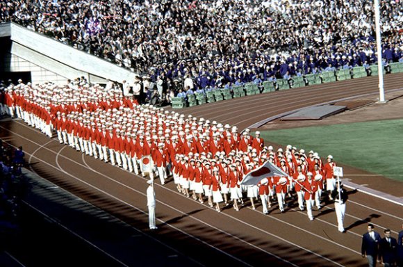 開会式で揃いの深紅のブレザーコートを着用し入場する日本選手団（1964年/東京）