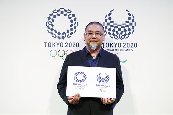 Asao Tokolo holds up his designs for the Tokyo Olympic and Paralympic logos.