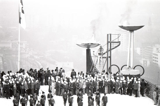 1976年インスブルック冬季オリンピック、開会式での聖火点火。1964 年大会で使用した聖火台 （右）と新しい聖火台（左）の両方に点火された