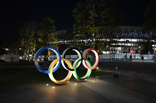 日本オリンピックミュージアム前のオリンピック・シンボル。背景は新国立競技場