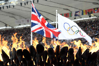 メインスタジアムの聖火とはためくユニオンジャック及びオリンピック旗（2012年 ロンドン）