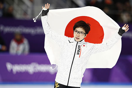 平昌オリンピック、スピードスケート女子500mで金メダルに輝き日の丸を持って声援に応える小平奈緒。（2018年）