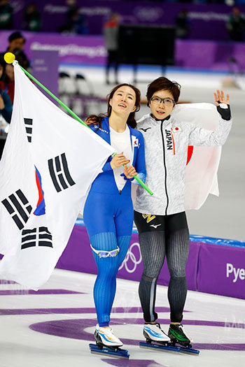 平昌オリンピック、スピードスケート女子500mのレース後、健闘を讃えあう金メダルの小平奈緒（右）と銀メダルの韓国の李相花
