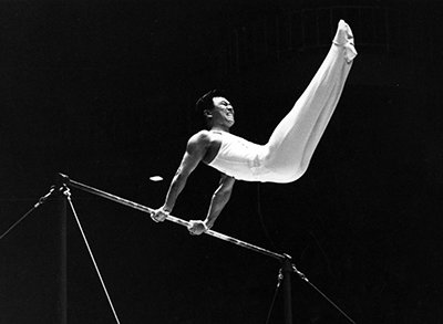 1964年東京大会で痛みをこらえながら鉄棒の演技をする小野