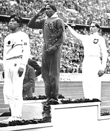 1936年ベルリンオリンピック走り幅跳びの表彰。中央はオーエンス、3位（左）は田島直人