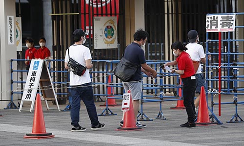 手の消毒をして入場する観客