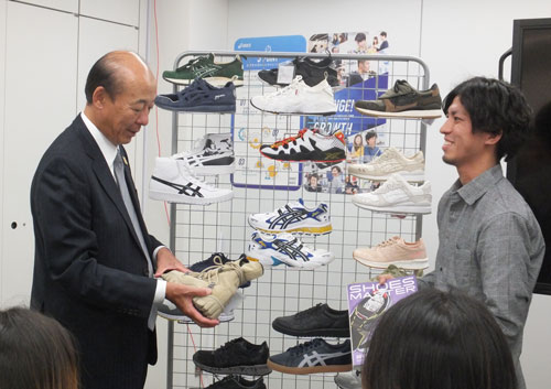商品について社員から説明を受ける(左)